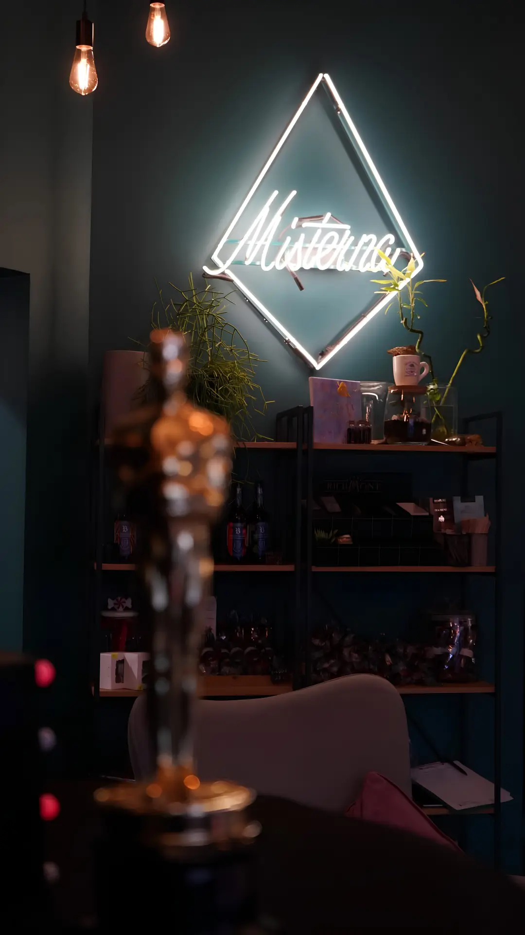Turkusowe wnętrze Misterna Cafe z rozświetlonym neonem marki